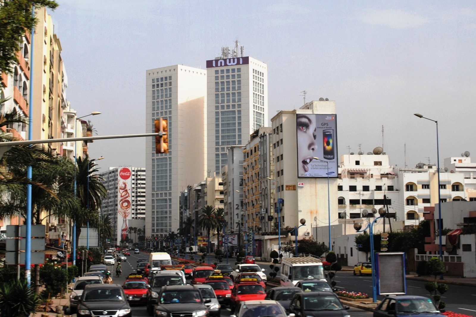 Voitures dans la circulation dense d'un boulevard de Casablanca, avec les deux tours du Twin Center en arrière-plan