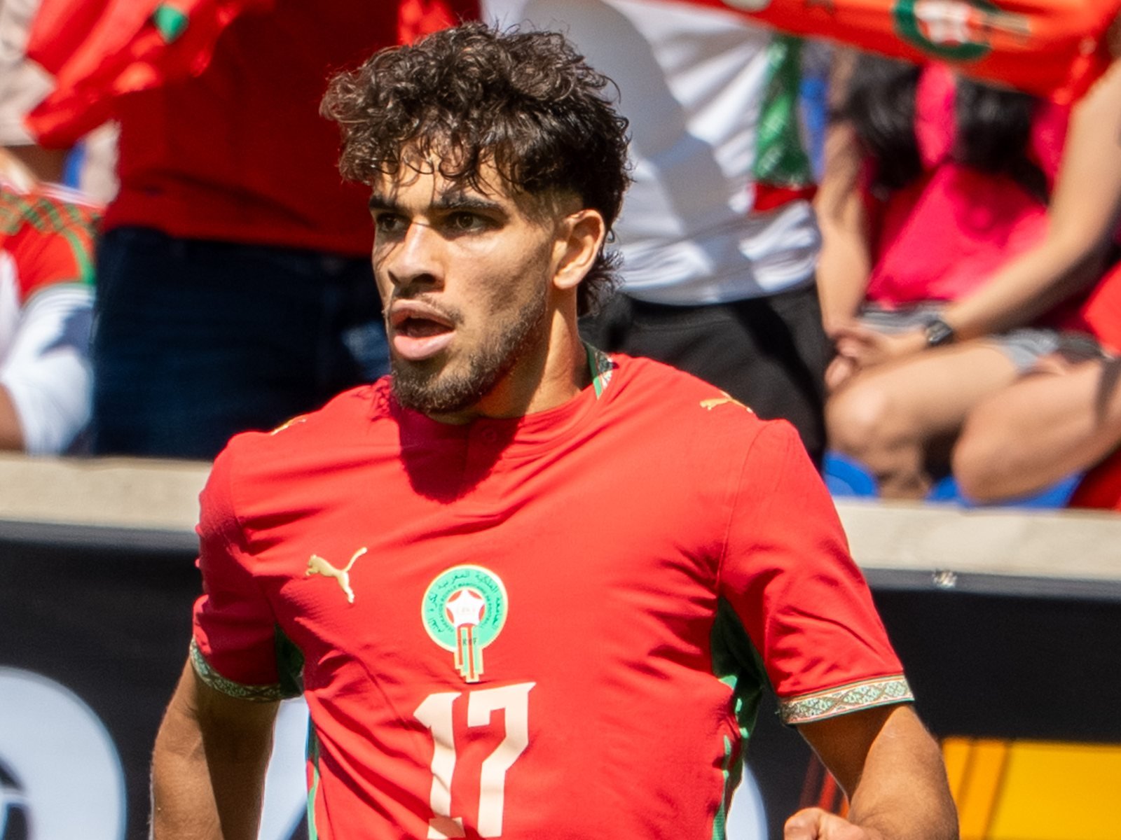 Abdessamad Ezzalzouli, maillot rouge du Maroc floqué du numéro 17, en pleine course le long de la ligne de touche, devant des supporters marocains