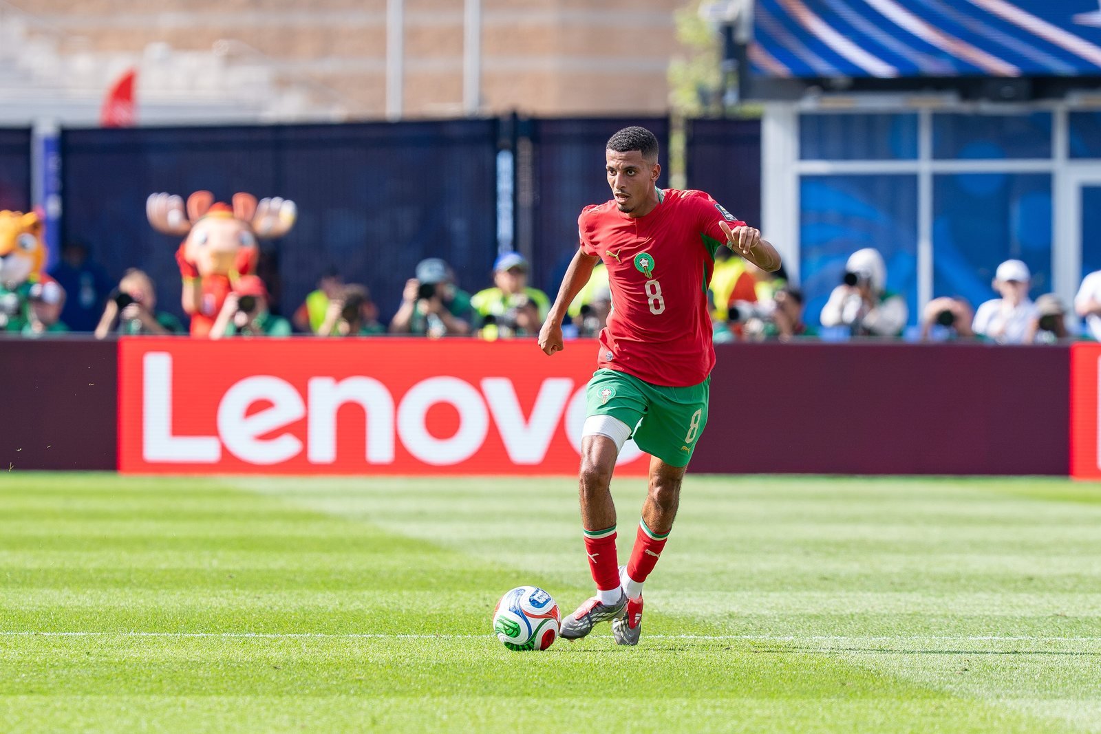 Azzedine Ounahi, en maillot rouge numéro 8 du Maroc, conduisant le ballon sur la pelouse