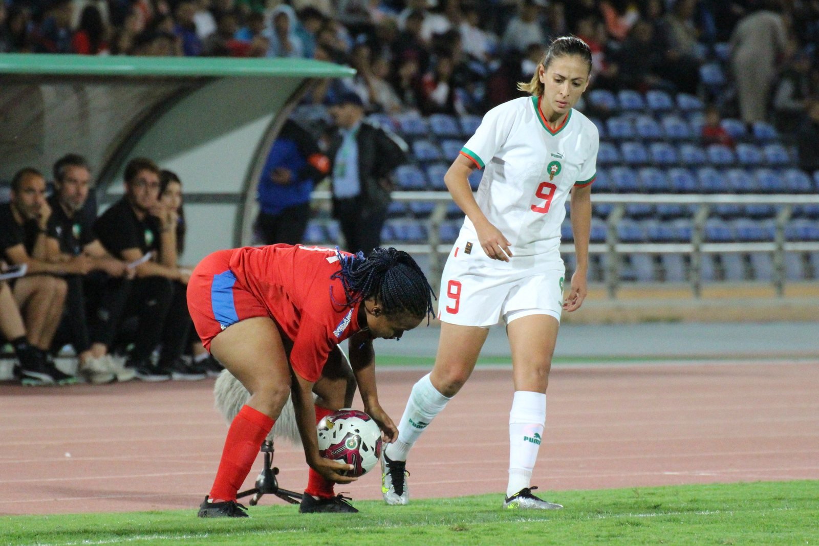 Ibtissam Jraidi, en maillot blanc numéro 9 du Maroc, à côté d'une joueuse adverse qui place le ballon
